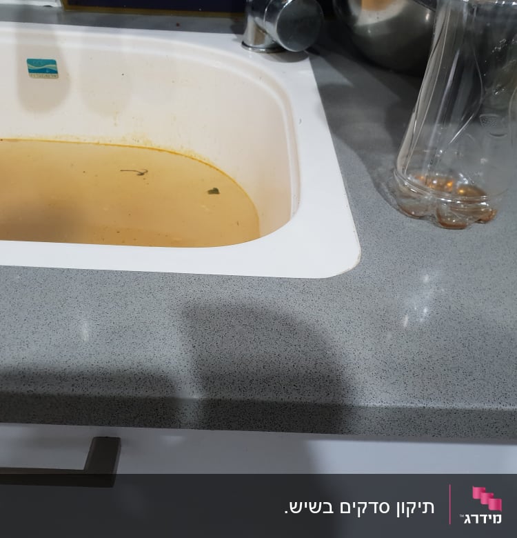 שיש אפור ליד כיור עם מים מלוכלכים